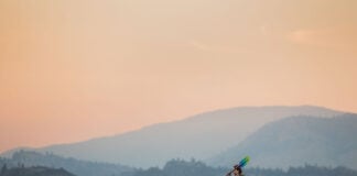 woman paddles the Eddyline Caribbean 10 kayak under rosy skies