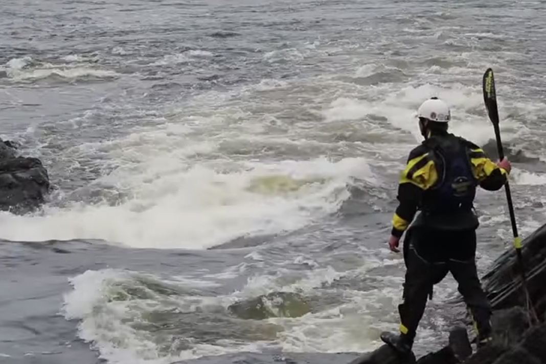 Joel Kowalski scouts a set of rapids at the side of the river.