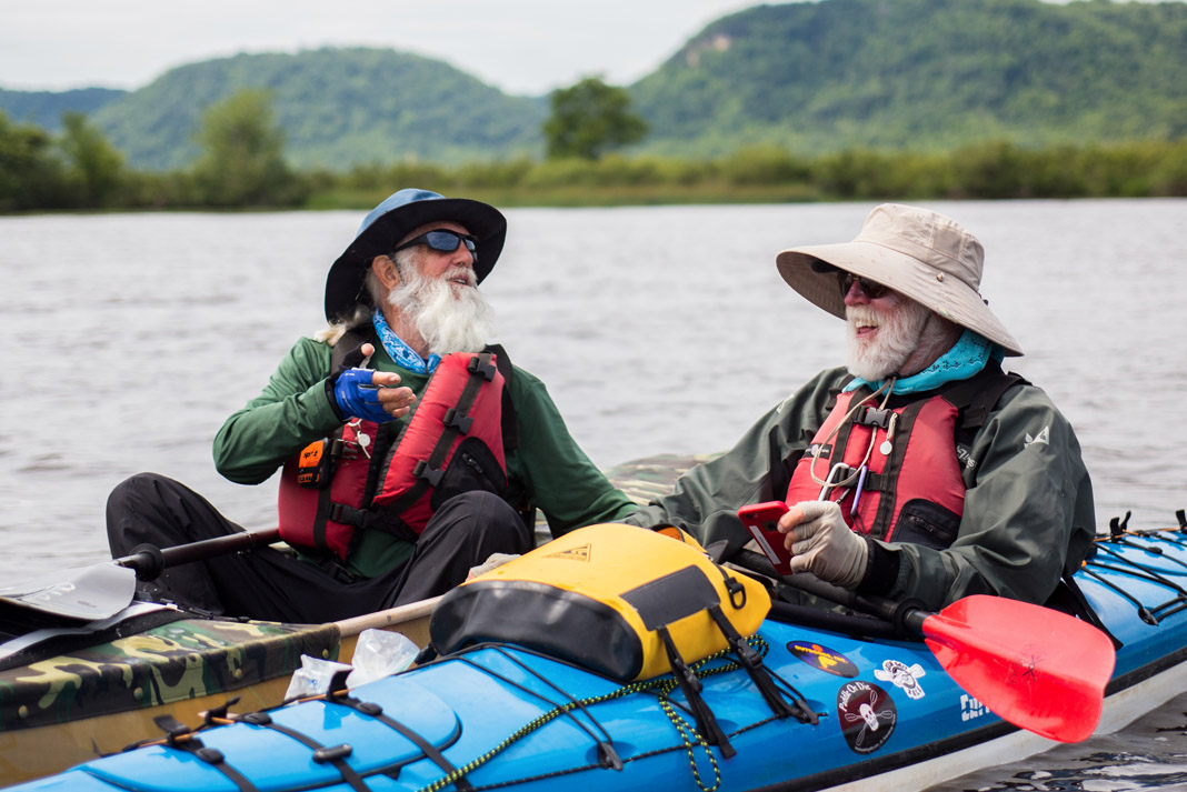 two men in kayaks laughing