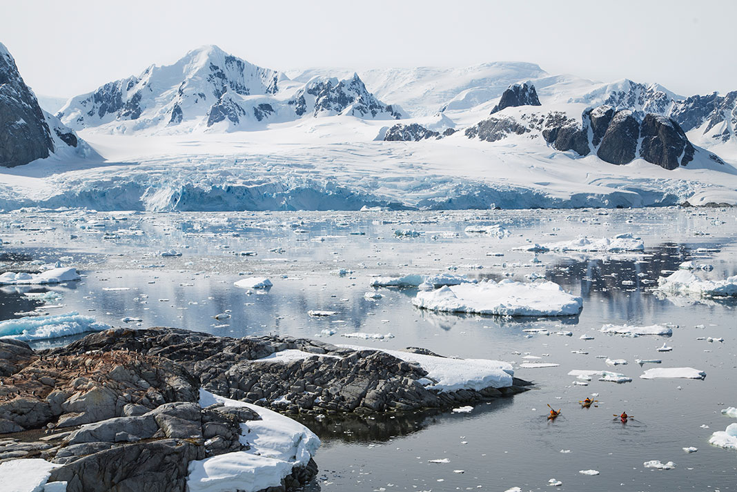 three kayaks in the waters of Antarctica on an eco tourism trip