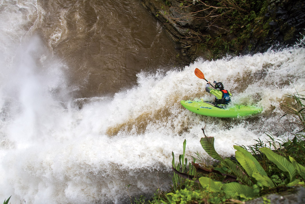 skilled kayaker dropping off a waterfall