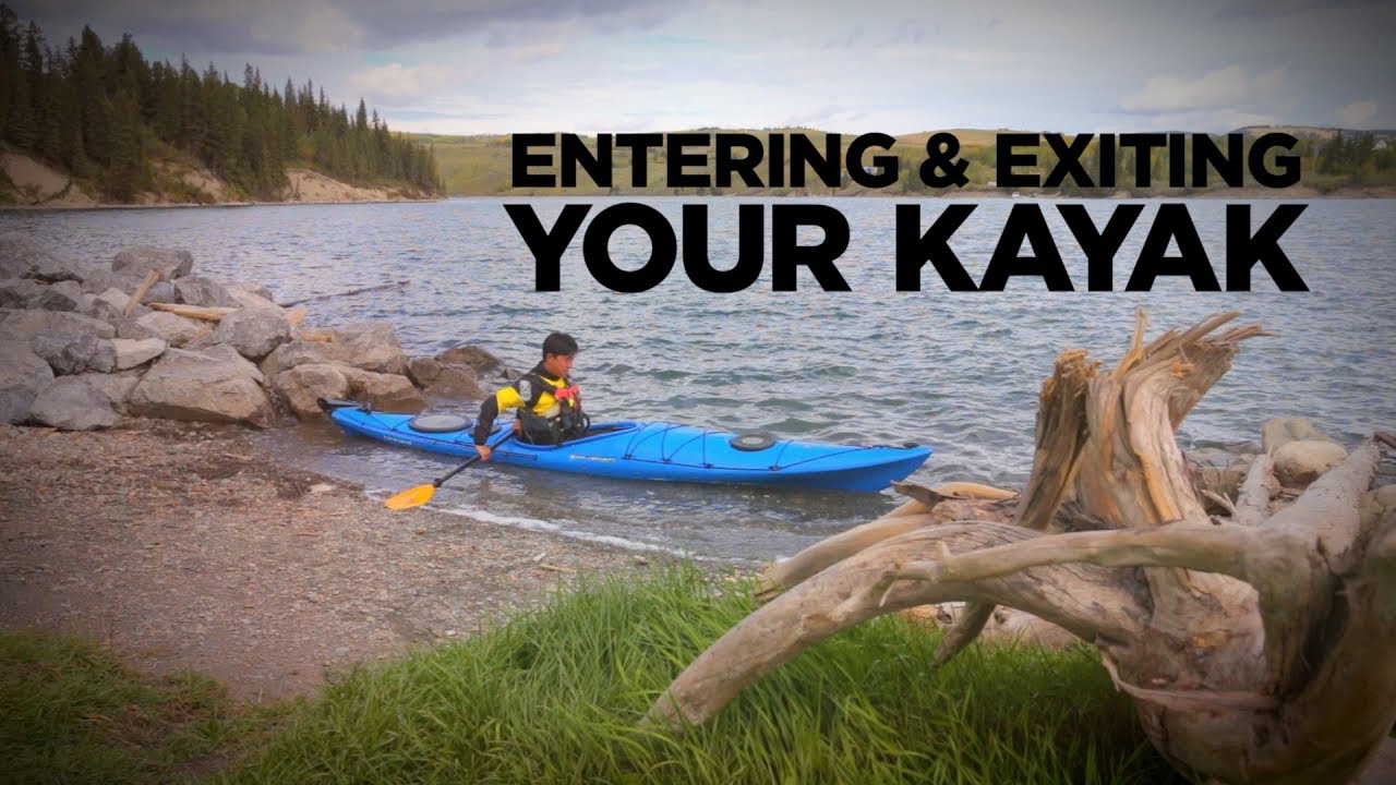 Paddler demonstrates how to get in a kayak.
