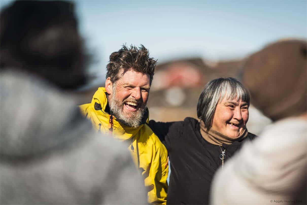 chef and expedition paddler Mike Keen stands and smiles with an Inuit woman while on his kayaking expedition around Greenland subsisting on an Inuit hunter's ancestral diet