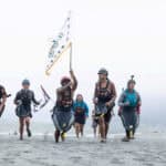 Indigenous Youth Kayakers Complete Historic First Descent Of Klamath River (Video) Paddle Tribal Waters youth carry a tribal flag at the mouth of the Klamath River on June 11