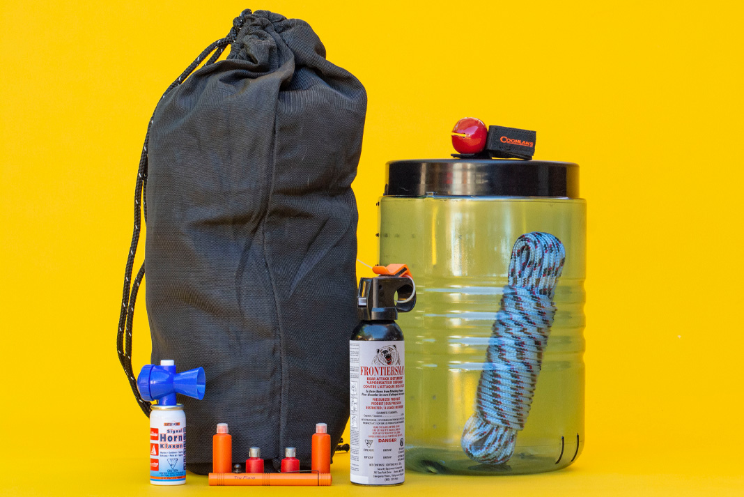 Camping gear for bear safety on a yellow background.