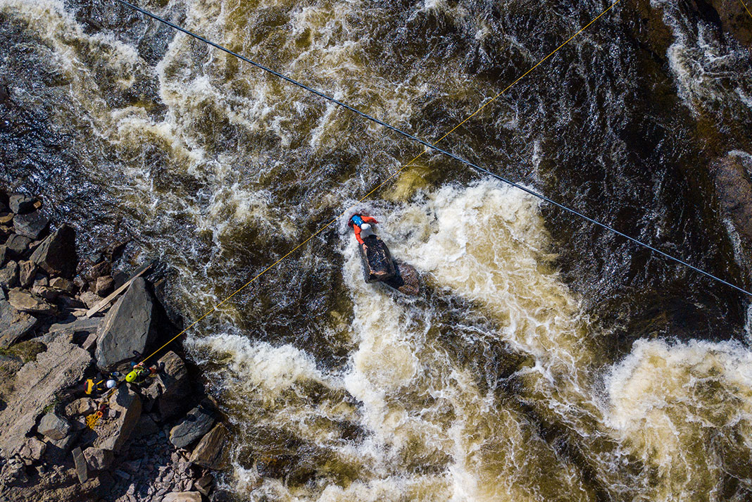 overhead shot of a group of whitewater paddlers performing a complex rescue aided by a thorough knowledge of knots
