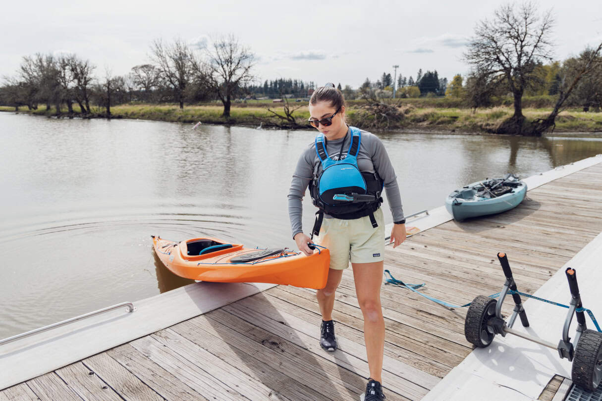 Paddler on dock taking kayak out of the water.