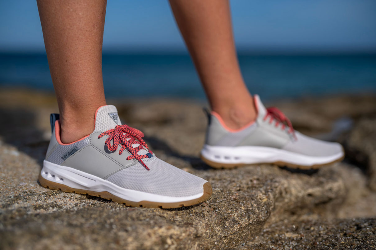 Feet shown of an angler wearing a pair of gray Columbia Tamiami water shoes, which are a great fit for fishing.