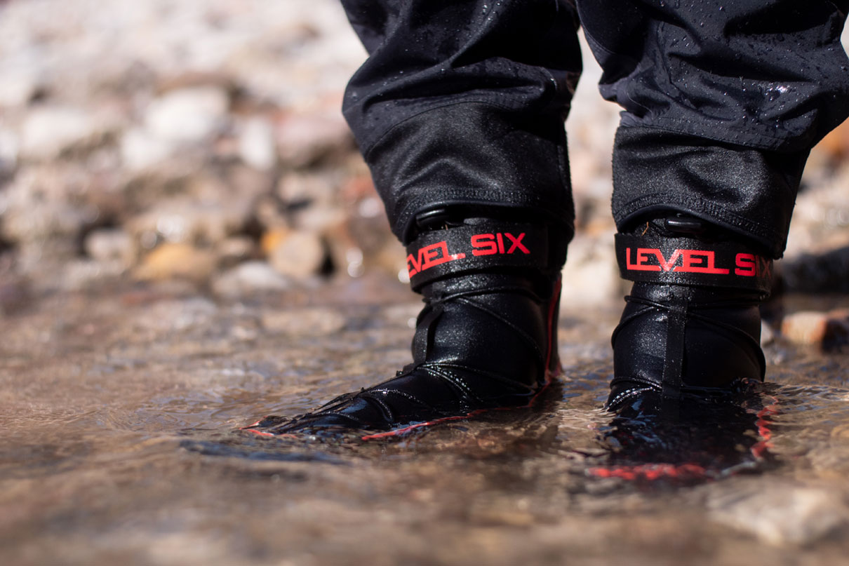 Close-up of a pair of Level Six Creek Boots 2.0 on a paddler standing in water.